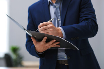 Real estate appraisal. Inspector with folder conducting property valuation at home, closeup