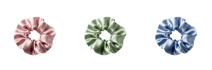 Set of three satin scrunchies in pastel colors on a transparent background