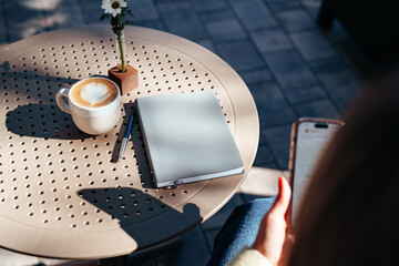 Enjoying a warm drink and writing notes at an outdoor cafe in the sunshine