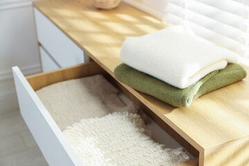 Stack of clean clothes on cabinet indoors, closeup