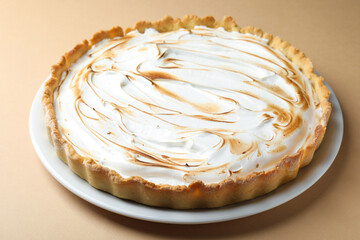 Delicious meringue pie on light brown table, closeup