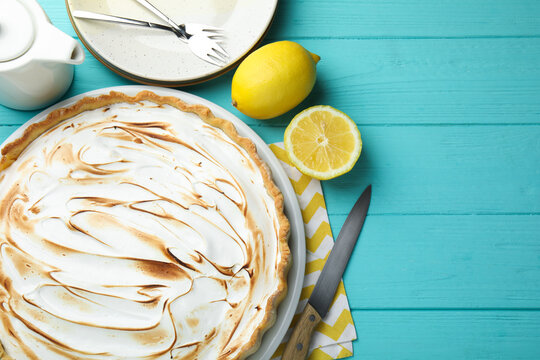Tasty lemon meringue tart served on turquoise wooden table, flat lay. Space for text