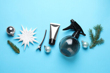 Hairdresser's tools, baubles and fir tree branches on light blue background, flat lay. Christmas greeting card