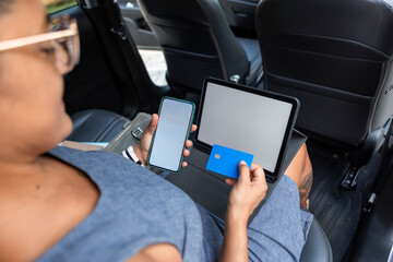 Businesswoman using devices in a car for work purposes