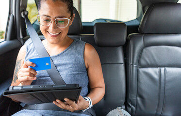 Businesswoman with tablet and credit card in car