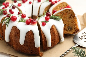 Tasty Christmas cake with cranberries and server on light table, closeup
