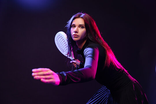 Female athlete engaged in an action-packed game with a racket indoors