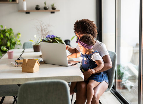 Mother and child using a laptop at home