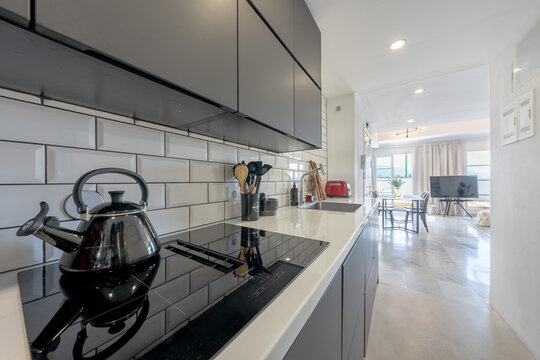 Modern kitchen with white subway tile backsplash and black appliances in mediterranean home