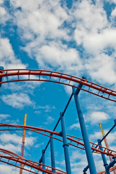 Roller coaster tracks under a bright blue sky