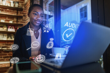 Young professional working on laptop with financial icons in a cozy cafe setting