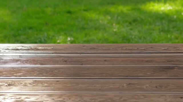 Empty rustic table top with blurred green grass landscape background. Abstract wooden counter. Mockup for promo, text or logo brand. Free space for text. Frame for display. Modern Presentation desk.