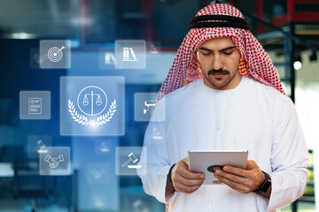 Professional man in traditional dress using tablet for legal research in modern office