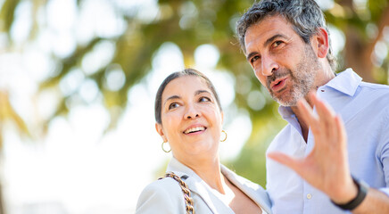 Smiling couple enjoying a sunny day while having a joyful conversation outdoors