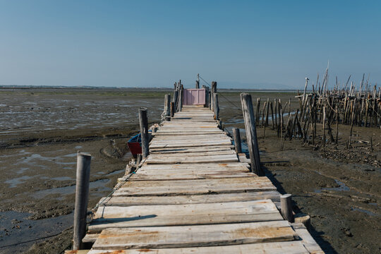 Weathered wooden pier on dried sea bed