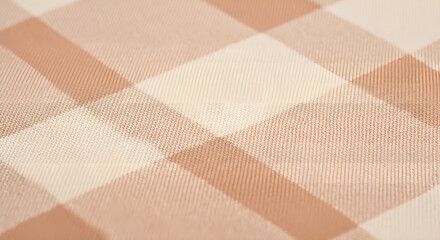 A close-up, abstract view of a tan and cream checkered fabric pattern, showcasing texture and light