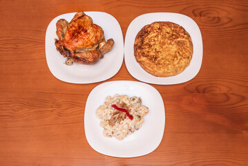 A hearty dish with a quarter of a roast chicken accompanied by a crispy, juicy potato omelet with a creamy interior, perfect for a home-cooked meal