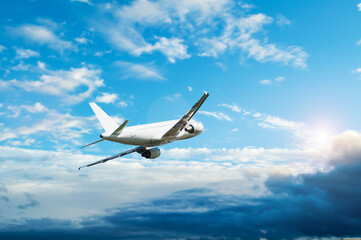 Air travel background with airplane in the flight, white passenger airplane with blank livery flying high in the sky
