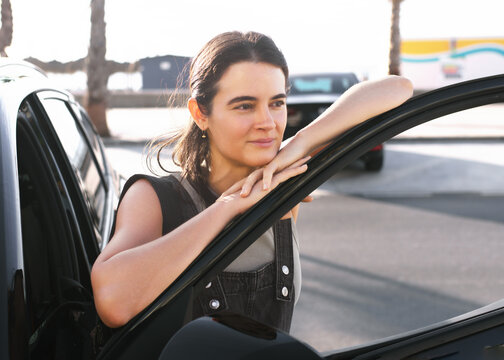 Woman relaxing beside her car on a sunny day