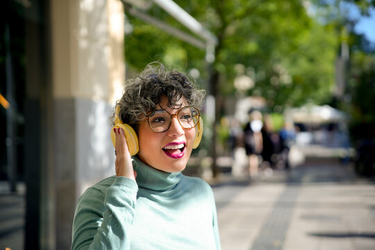 Happy tech woman enjoying music on headphones