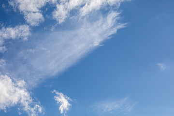 Blue sky with wispy white cirrus clouds. Weather, atmospheric background, nature. Real photo