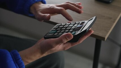 Working in a bank and using a calculator to calculate profits.
A businessman with a calculator doing mathematical calculations.
An adding machine on a banker's desk. - Powered by Adobe