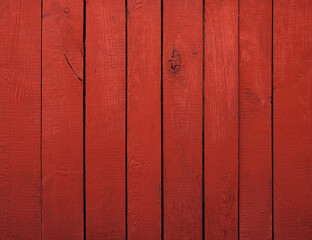 Close up of red painted wooden fence panels.
