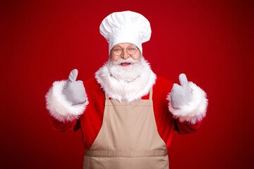 Santa chef in white hat and apron smiles warmly in a red studio ready for Christmas celebration with family feast and festive mood