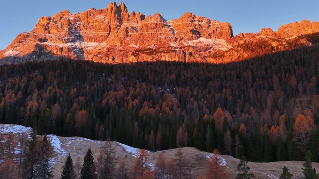 Drone flying over autumn forest in the Dolomites at sunrise, autumn mountain landscape near Lago di Federa in the Dolomite Apls, Cortina D'Ampezzo, South Tyrol, Dolomites, Italy