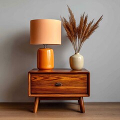 Mid century modern wooden nightstand with orange lamp and dried grass decor
