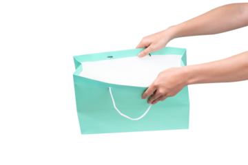 Hand holding green shopping bag with empty space on transparent background