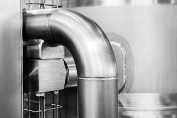 Stainless steel pipes attached to stainless steel tank with industrial food production machine,...