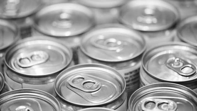 Row of aluminum cans for beer or other drinks on conveyor after pouring the drink inside close-up, industrial concept background