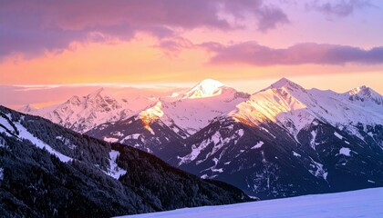A breathtaking panoramic view of snow-covered mountain peaks illuminated by the golden and pink hues of a sunset.