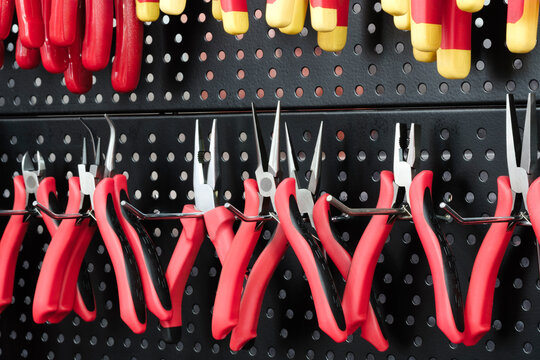Tool nippers, pliers, and tongs are displayed on a stand in a tool market, tools industry concept background - Powered by Adobe