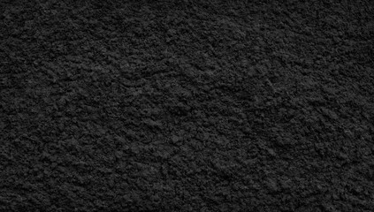Fototapeta premium Black dark rough pimpled textured abstract background for wallpaper banner template page design, black plaster concrete wall.