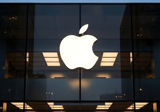 Apple logo illuminated on a building facade at nighttime view