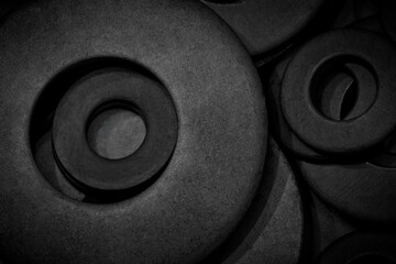 Dark black industrial background with many metal nuts, washers, rings for industrial background...