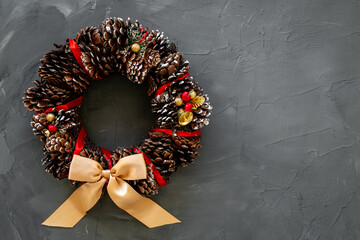 Christmas wreath made of tree bark and dry cones on the wall. New Year DIY decoration
