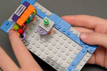 Naklejka premium Building a colorful LEGO creation on a gray surface