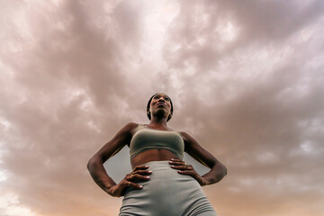 Athlete in sportswear standing confidently on urban running track outdoors
