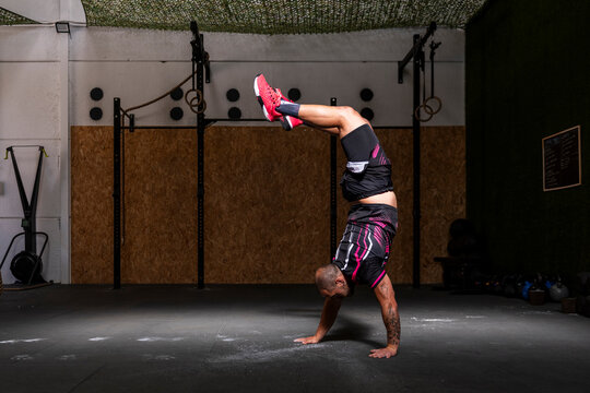 Sportsman doing handstand at gym