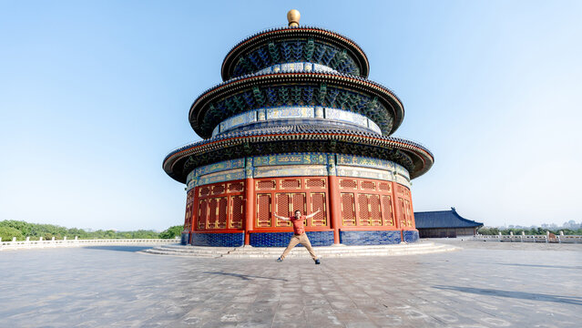 Man jumping in front of the Hall of Prayer for Good Harvests