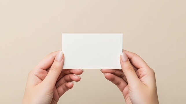 Hands Holding Blank White Business Card Against Soft Pastel Background for Branding or Design Purposes in Professional Settings