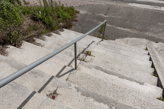 Urban Concrete Staircase With Handrail and Deteriorating Surface Repair - City Infrastructure Maintenance and Public Space Safety Concept