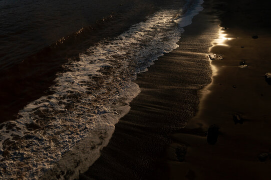Dark waves on golden Asturias beach