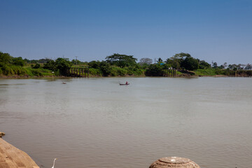 Man sitting at a traditional wooden canoe at the Sinu River in Lorica, Colombia