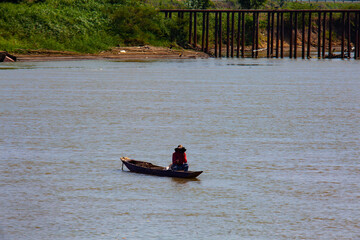 Man sitting at a traditional wooden canoe at the Sinu River in Lorica, Colombia