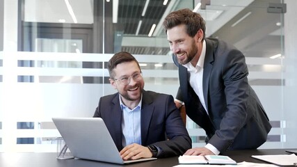 Manager praises employee for excellent job at laptop at a workplace in a business office. Businessman motivates colleague for work well done. Positive interaction, teamwork, collaboration, and success