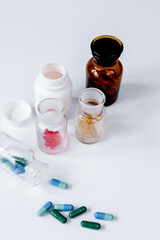 colored pills in glass bottles on white background